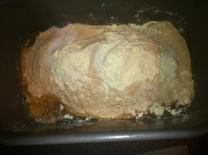 stuff dumped in the bread pan to make whole wheat bread -- look at the yeast going to town already